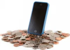 Blue smartphone leaning on a pile of scattered coins and cash
