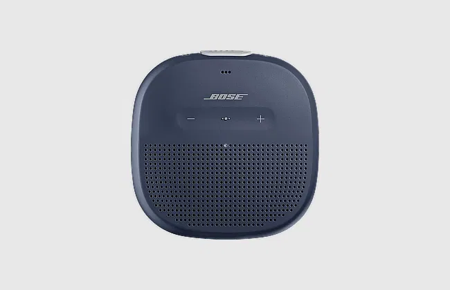 Front view of navy blue Bose Bluetooth speaker with rounded edges, front grille, and top-mounted volume buttons.