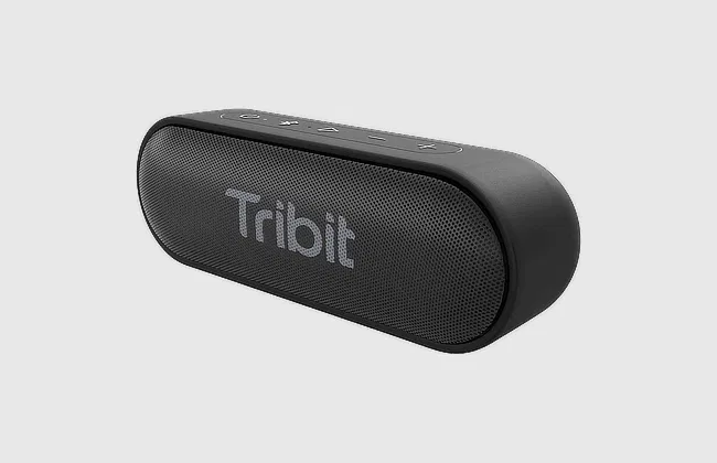 Front view of a black Tribit Bluetooth speaker with rounded edges, top control buttons, and mesh grille on light gray background.