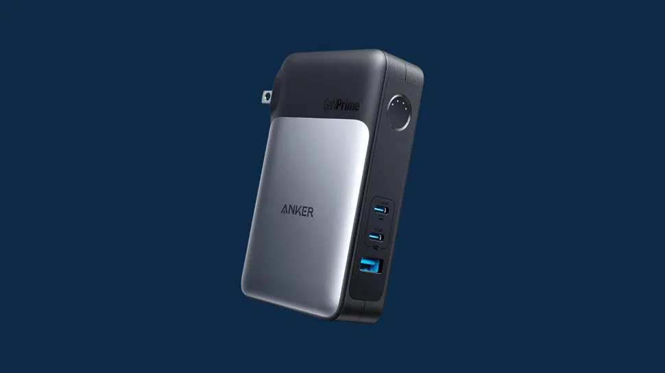 Front view of silver and black Anker GaNPrime charger showing three USB-C, one USB-A port, foldable plug; dark blue background.