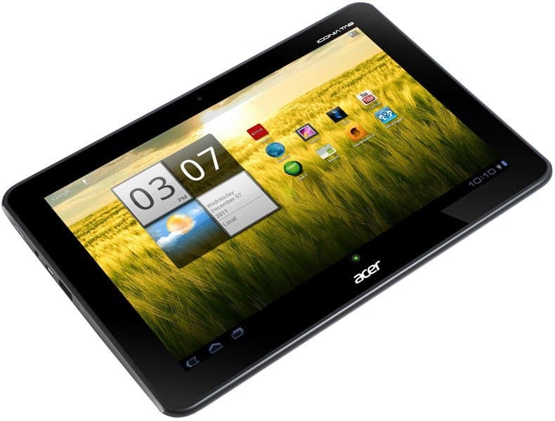 Acer tablet, front angled view, showing home screen with weather widget, time, date, app icons on a green field background.