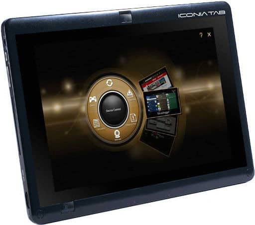 Front view of Acer ICONIA TAB tablet in black, screen on with circular UI, multiple icons, and overlapping windows on a dark background.
