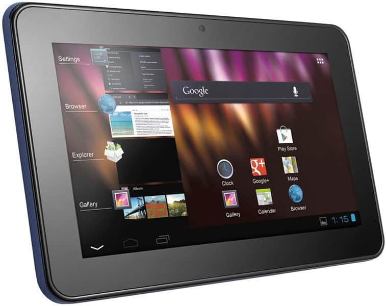 Front view of a black Android tablet, home screen visible with Google apps and digital clock at 1:15. Brand/model not shown.