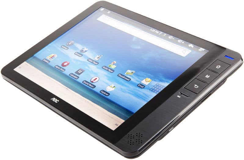 Front view of AOC tablet on white surface, black bezel, beach home screen, app icons, right-side physical buttons visible.
