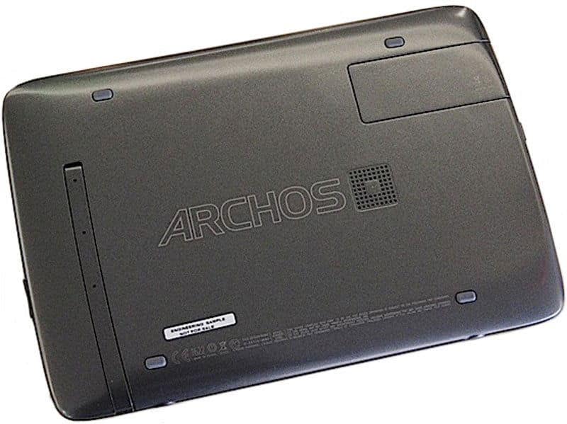 Rear view of Archos tablet shows large ARCHOS branding, multiple ports, screws, and a removable panel on black casing.