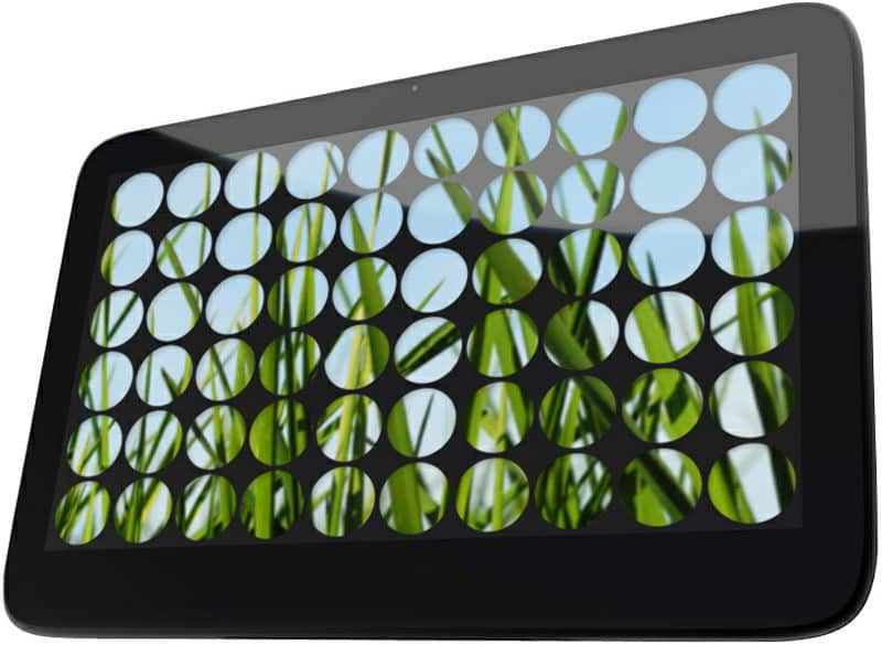 Front view of a black tablet displaying a screen with circular cutouts revealing grass and blue sky in the background.