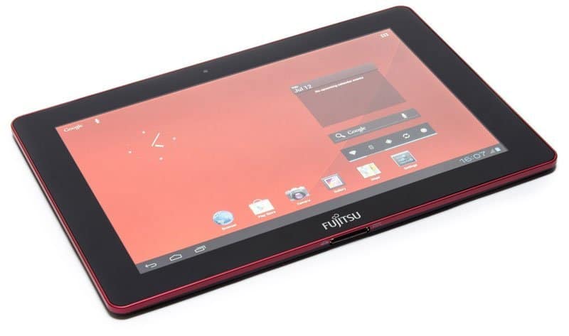 Front view of a black Fujitsu tablet with red trim on white surface, displaying Android home screen with app icons and widgets.