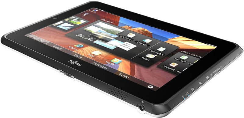 Fujitsu tablet angled view showing screen with app icons, side buttons, and headphone jack visible along the edge.