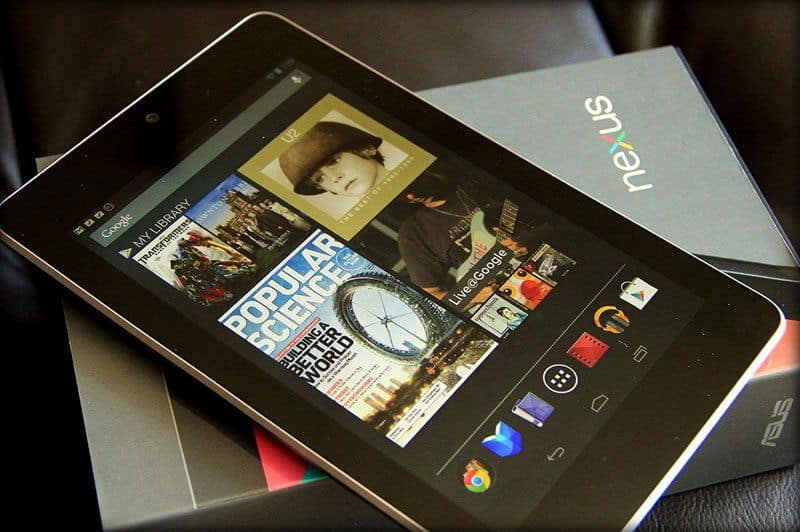 Front view of black Asus Nexus tablet showing magazines, music, and apps, resting on original box with Nexus and Asus branding.