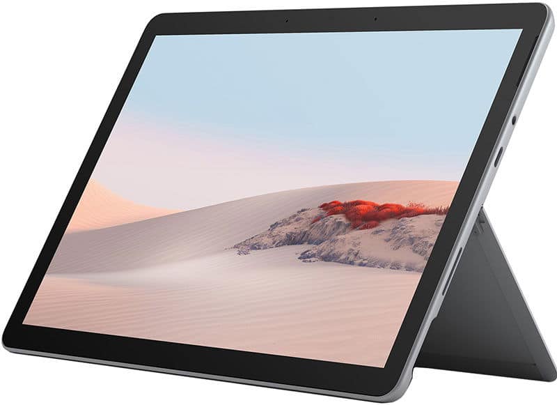 Front view of a tablet in landscape mode on its kickstand, detachable keyboard attached, screen displays a desert with red plants.