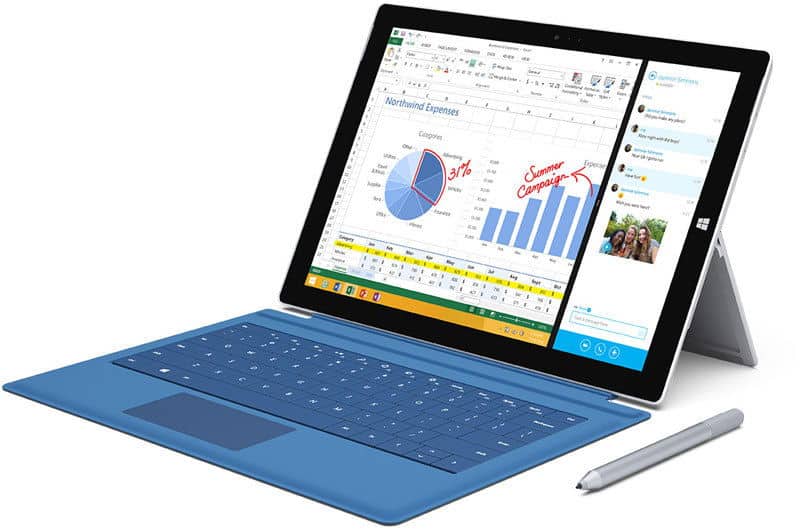 Microsoft Surface Pro with blue keyboard cover and stylus, front view, split screen showing spreadsheet charts and messaging app.