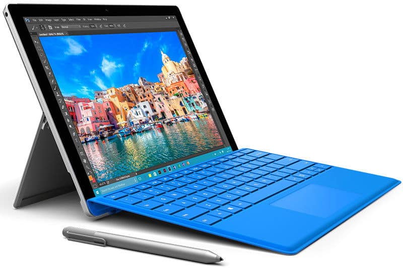 Front view of Microsoft Surface tablet with blue keyboard and stylus, showing a photo editor, on a white surface.
