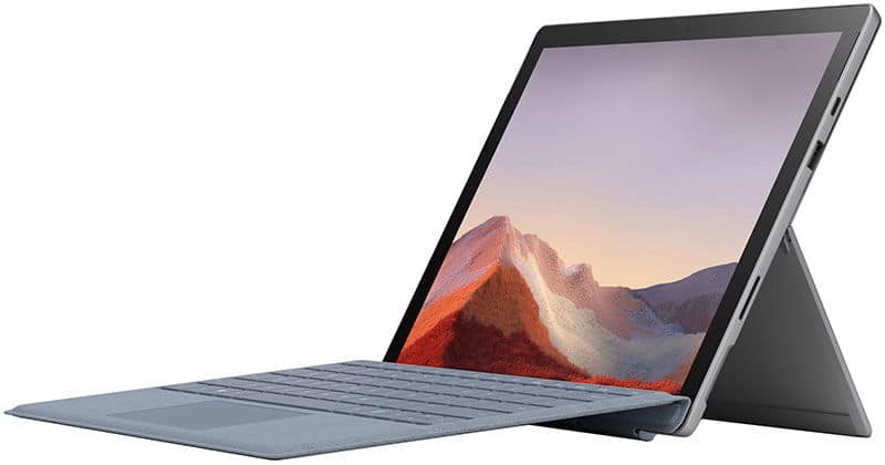 Front view of a grey Microsoft Surface Pro with detachable keyboard and kickstand, screen shows mountains and pink sky.