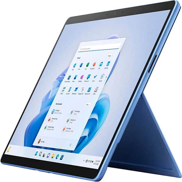 Front view of a blue tablet on its kickstand, screen on and showing Windows 11 start menu and desktop icons.