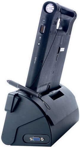 Front view of a black tablet docked vertically in a matching station with VGA port and stylus; brand/model not specified.