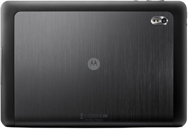 Rear view of black Motorola tablet; brushed metal finish, center logo, rear camera with flash in top right corner.