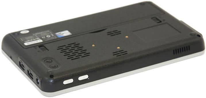 Close-up of the rear underside of a black tablet, highlighting vents, ports, and removable battery compartment. Brand/model not shown.