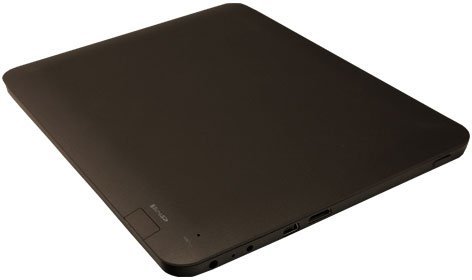 Closed black tablet (brand/model not specified) viewed from angled top; thin, rounded edges, side ports, smooth surface, small corner label.