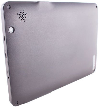 Rear close-up of a gray tablet showing speaker grill, round button, side ports, and small logo. Brand/model not identifiable.