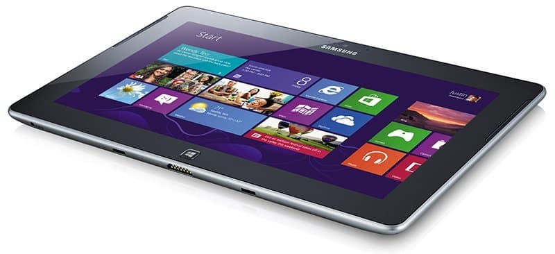 Samsung ATIV Tab front view on white surface, displaying Windows 8 start screen with colorful app tiles and Samsung logo visible.