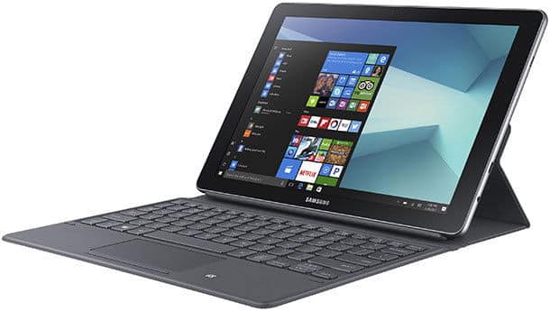 Front view of Samsung tablet with detachable keyboard on stand, showing Windows OS app tiles. Model appears to be Galaxy Book.