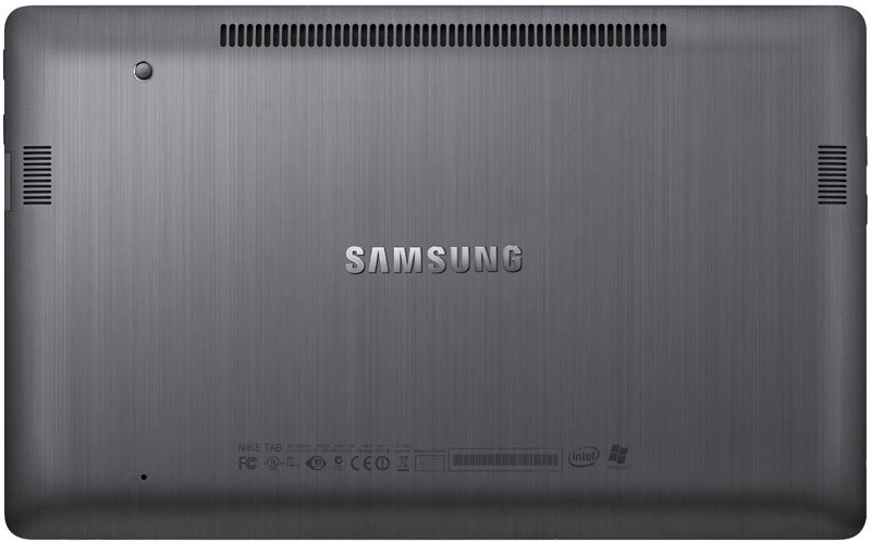 Samsung Galaxy Book underside with brushed metal finish, ventilation grills, speakers, certification labels, and centered logo.
