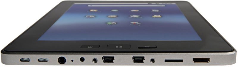 Bottom-edge close-up of a tablet showing USB, HDMI, headphone jack, microSD slot, control buttons, and app icons on screen.