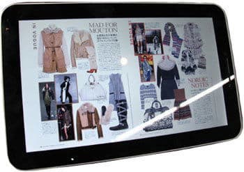 Front view of a tablet showing a digital fashion magazine spread with English and Japanese text, photos, and accessories.