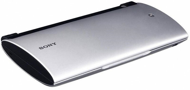 Sony rectangular silver remote control, black edge, front view; Sony logo left, small round button right, white background.