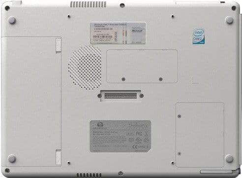 Bottom view of a silver laptop with ventilation grills, screws, battery slot, labels, and Intel Core 2 sticker upper right.