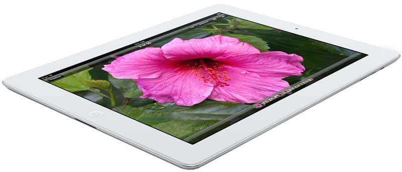 White tablet, possibly Apple iPad, front angled view showing a pink hibiscus flower display; device rests on white surface.