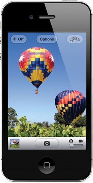 Front view of Apple iPhone 4s showing camera app with two hot air balloons above green trees on a clear blue sky background.
