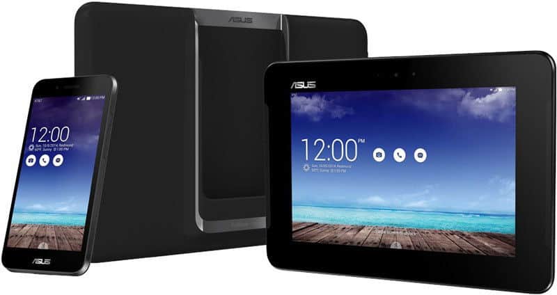 Front view of black Asus PadFone X beside docking station and tablet showing ASUS logo, beach wallpaper, and app icons at 12:00 PM.