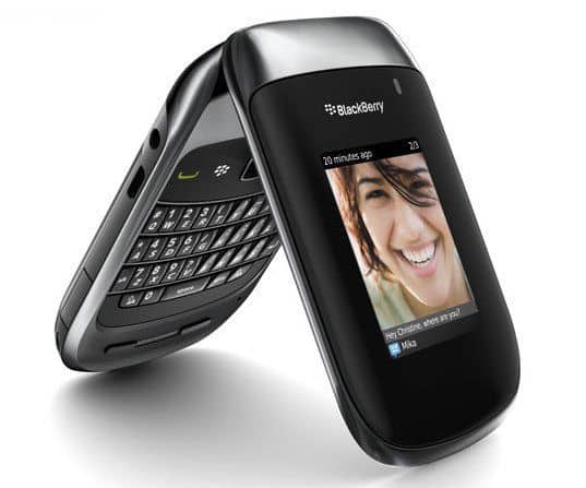 Front view of BlackBerry 9670 Style flip phone open, QWERTY keyboard visible, glossy black and silver finish, outer screen on.