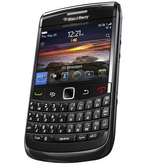 BlackBerry Bold 9780 front view, displaying home screen with sunset landscape wallpaper, physical QWERTY keyboard, and app icons