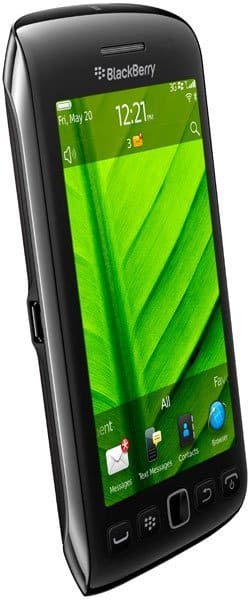 BlackBerry Torch 9860 smartphone shown at an angle, displaying green leaf wallpaper on screen with time 12:21