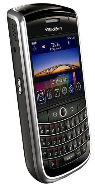 BlackBerry Tour 9630 front view with screen displaying landscape photo, time, and app icons above QWERTY keyboard