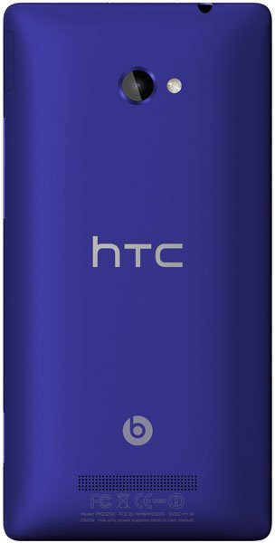 Rear view of purple HTC Windows Phone 8X showing rear camera with flash, HTC logo, Beats Audio logo, and bottom speaker grill.