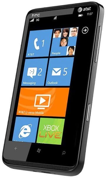 HTC HD7S front view with Windows Phone home screen displaying app tiles for calls, people, messaging, Outlook, and Xbox Live