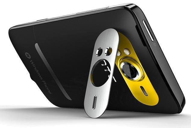 HTC HD7S smartphone shown from rear angle with white and yellow protective stand attached to black device back