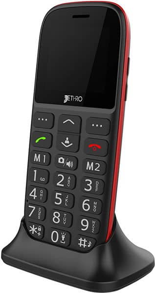 Front view of black and red Jethro SC318 phone in charging dock, large keypad with M1/M2 shortcuts, screen off.