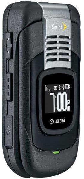 Kyocera DuraCore flip phone, open view, showing black exterior with silver accent and display screen reading 7:00 PM