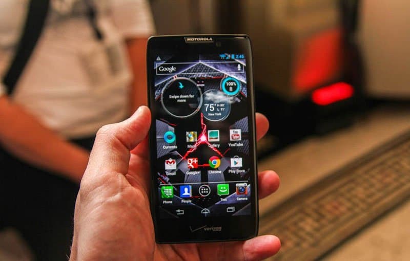 Motorola DROID RAZR MAXX HD front view displaying home screen with Google widgets and app icons in hand