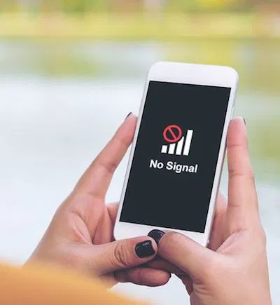 Person holding white phone displaying "no signal" message with signal bars icon on screen
