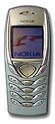 Nokia 6100 mobile phone, front view, with curved metallic silver body and small screen displaying graphics