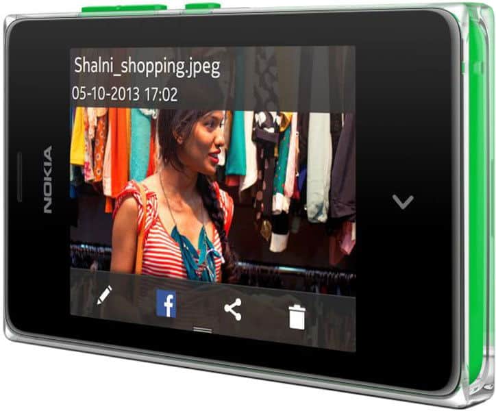 Nokia Asha 502 front view displaying a photo with sharing options below; shows woman near clothing racks, dated 05-10-2013.