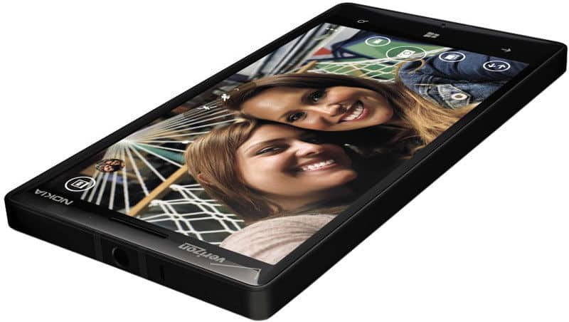 Nokia Lumia Icon smartphone displayed at an angle, showing its black front with a screen displaying two people and colorful app icons at the top
