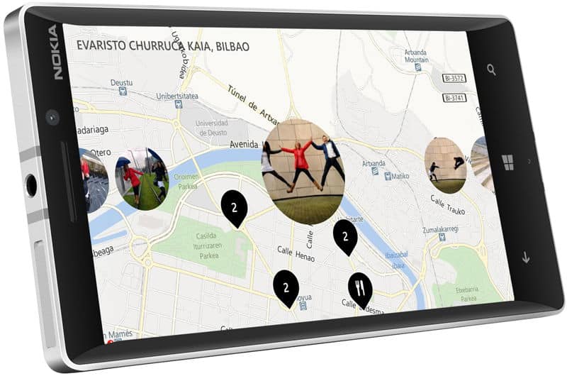 Nokia Lumia 930 displaying a map of Bilbao with location pins and photo overlays, shown from the front at an angle