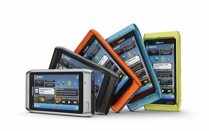Nokia N8 smartphones displayed in five colors: white, black, orange, blue, and lime green, shown from the front with screens visible