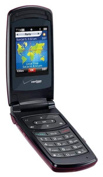 Front view of black Verizon PCD Escapade flip phone open, showing screen with world clock and large-button keypad.